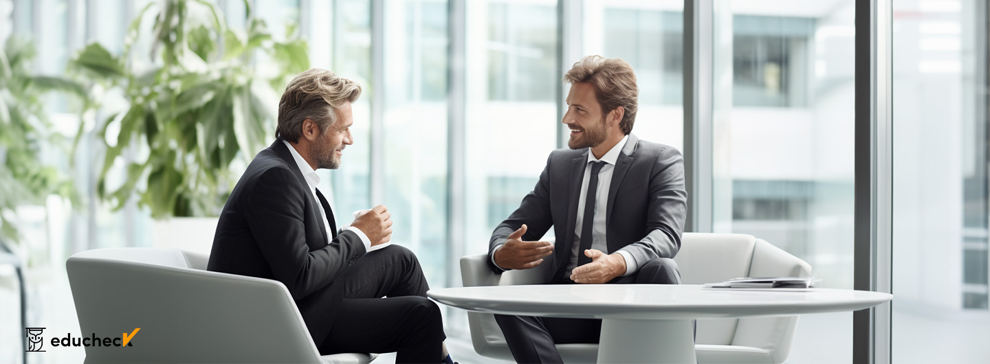 Zwei Männer im Anzug sitzen sich gegenüber und führen eine Diskussion