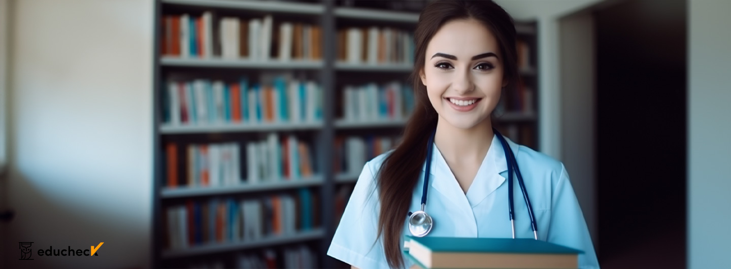 Pflegepädagogik Studium: Junge Frau mit Stethoskop um den Hals und Lehrbüchern in der Hand lächelt in die Kamera