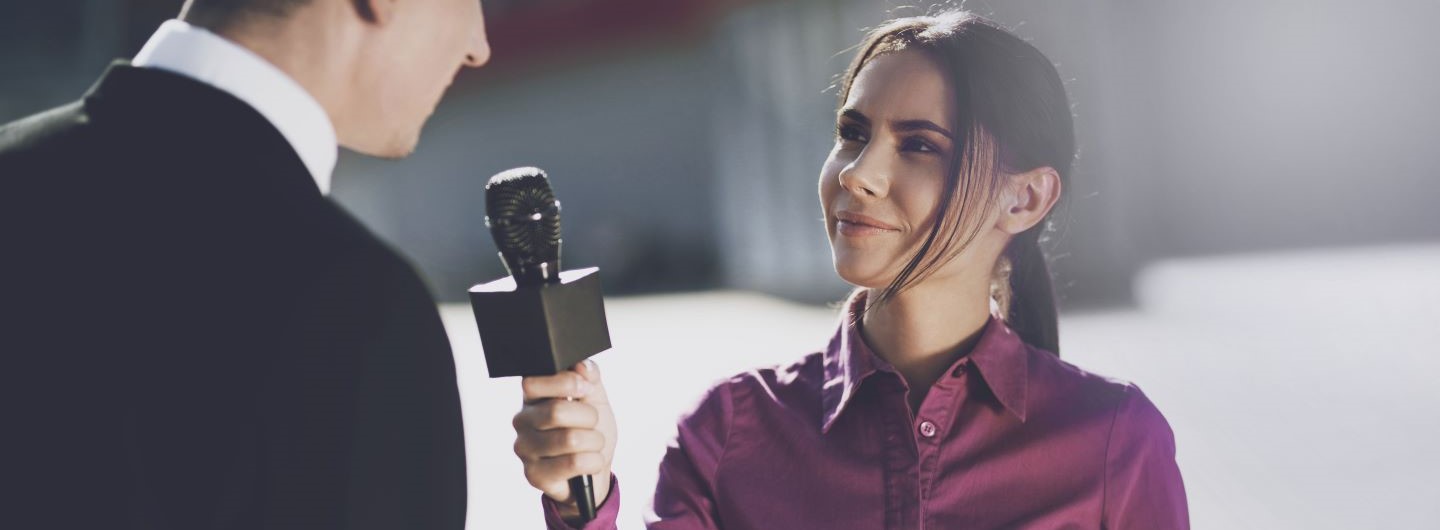 Frau mit Mikrofon interviewt eine Person
